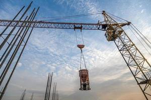 eine niedrige Winkelaufnahme eines Krans mit Ausrüstung auf einer Baustelle in der Nähe einer neuen Gebäudeinfrastruktur foto