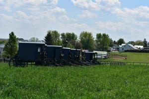 Farm mit geparkten Amish-Buggys und Karren foto