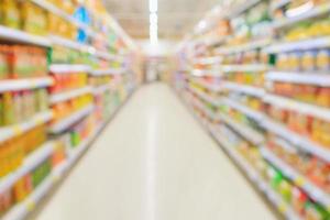 supermarktgang mit produktregalen innen defokussierter unschärfehintergrund foto