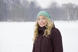 frau, die auf schneebedecktem feld geht foto