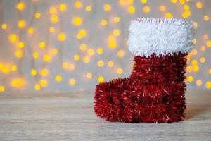 roter weihnachtsstiefel auf holztisch mit bokeh hellem hintergrund foto