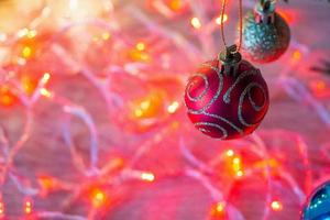 weihnachtsbaum verziert mit roter kugel auf tannenzweigen mit hellem hintergrund foto