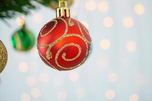 weihnachtsbaum verziert mit roter kugel auf tannenzweigen hintergrund foto