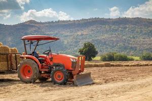 traktor auf dem landwirtschaftsgebiet mit berg und blauem himmel foto