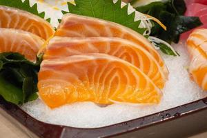 rohe Lachs-Sashimi-Scheibe auf Eis japanisches Essen foto