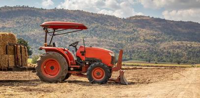 traktor auf dem landwirtschaftsgebiet mit berg und blauem himmel foto