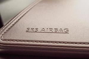 Airbag-Sicherheitsschild auf brauner Lederstruktur im modernen Auto foto