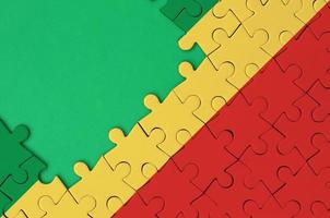 die Kongo-Flagge ist auf einem fertigen Puzzle mit freiem Platz für grüne Kopien auf der linken Seite abgebildet foto
