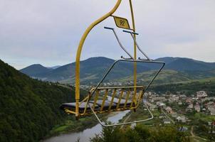 die sitze der seilbahn auf dem hintergrund des makovitsa-berges, einem der karpaten foto