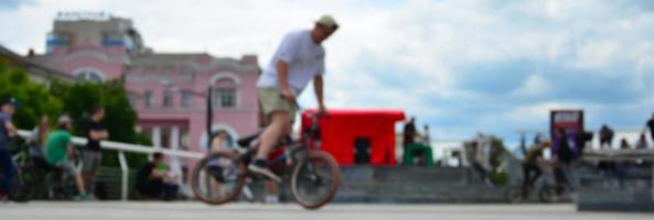 defokussiertes Bild vieler Leute mit BMX-Rädern. Treffen von Fans von Extremsportarten foto