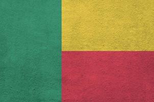 benin-flagge in hellen farben auf alter reliefputzwand dargestellt. strukturierte Fahne auf rauem Hintergrund foto