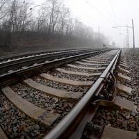 die Bahngleise an einem nebligen Morgen. viele schienen und schwellen gehen in den nebligen horizont. Fisheye-Foto mit erhöhter Verzerrung foto