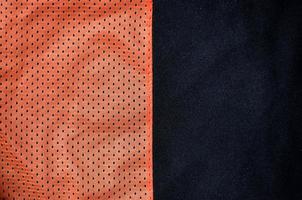 Sportbekleidung Stoff Textur Hintergrund. Draufsicht auf die Textiloberfläche aus rotem Polyester-Nylon-Tuch. farbiges Basketballshirt mit freiem Platz für Text foto