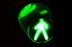 Nachtfoto einer Fußgängerampel, die grün leuchtet foto