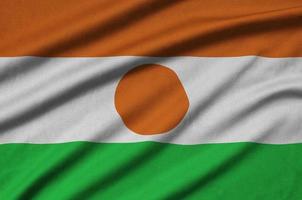 Die niger-Flagge ist auf einem Sportstoff mit vielen Falten abgebildet. Sportteam-Banner foto