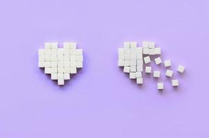 Ein paar Herzen aus Zuckerwürfeln liegen auf einem trendigen pastellvioletten Hintergrund foto