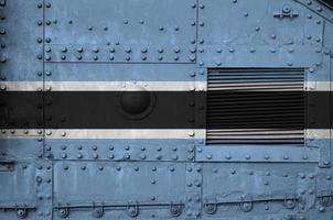 botswana-flagge auf seitenteil des militärischen gepanzerten panzers in der nähe. konzeptioneller hintergrund der armee foto