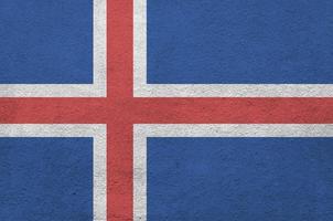 isländische flagge in hellen farben auf alter reliefverputzwand dargestellt. strukturierte Fahne auf rauem Hintergrund foto