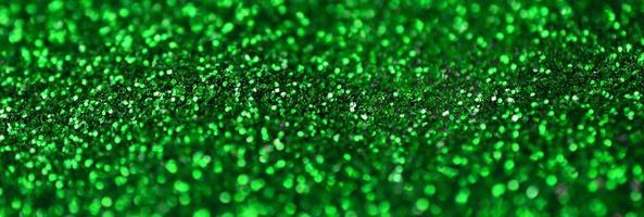 eine riesige Menge grüner Zierpailletten. Hintergrundbild mit glänzenden Bokeh-Lichtern aus kleinen Elementen foto