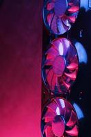 eine grafikkarte mit einer reihe von lüftern mit cyanotisch lila hintergrundbeleuchtung in futuristischem design. foto