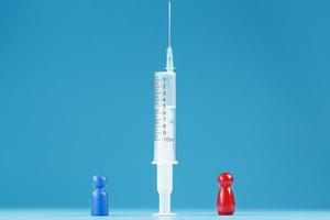 Impfen oder verweigern Sie eine Spritze mit einem Impfstoff mit zwei Personengruppen, einem roten und einem blauen Menschenmodell. foto