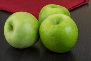 grüner Apfel auf Holz foto