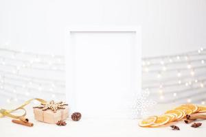 null abfall natürliche weihnachtsdekoration mit weißem mock-up-rahmen auf dem tisch. nahaufnahme, kopierraum foto
