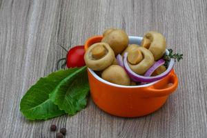 marinierte Champignons in einer Schüssel auf Holzhintergrund foto