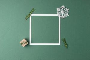 weihnachtsgrüner minimaler hintergrund mit weißem rahmen und geschenk. Zero Waste Weihnachtsferienkonzept. flach liegend, kopierraum foto