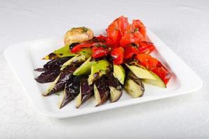 gegrilltes Gemüse auf dem Teller und weißem Hintergrund foto