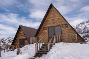 die von Schnee umgebenen Holzhütten. ein Erholungsgebiet in den Bergen foto