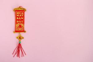 traditionelle vietnamesische und chinesische neujahrsdekoration rote und goldene farben auf rosa hintergrund, draufsicht. foto