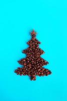 weihnachtsbaum aus kaffeebohnen und verziertem anisstern auf blauem hintergrund, draufsicht. foto