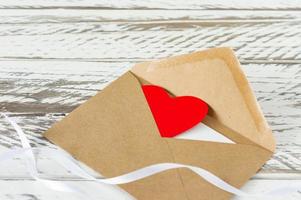 Liebesbrief mit Papierherz auf Holzhintergrund. festliche grußkarte zum valentinstag.