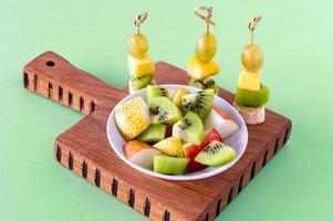 veganes frühstück. Vielzahl von Früchten auf Holzschneidebrett, selektiver Fokus, Obstsalat foto