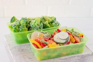 Mischung aus gefrorenem Gemüse in Aufbewahrungsbehältern aus Kunststoff. Essensvorräte für den Winter. foto