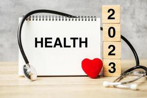 2023 frohes neues Jahr für Gesundheitswesen, Versicherungen, Wellness und medizinisches Konzept. Stethoskop des Arztes auf dem Tisch foto