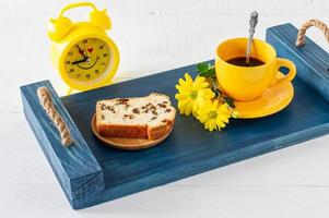 Stücke Rührkuchen mit Rosinen und eine Tasse Kaffee, serviert auf einem Tablett. Morgen leckeres Frühstück foto