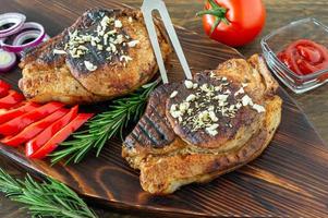 frisches saftig gebratenes rotes fleisch auf holzbrett, mit gewürzen und gemüse. Restaurantessen, leckeres Gericht foto