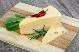 Gelber Käse auf Holzbrett und Holzhintergrund foto