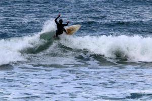 surfen auf hohen wellen am mittelmeer im norden israels. foto