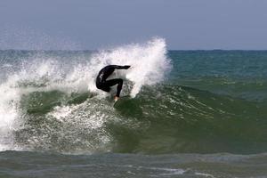 surfen auf hohen wellen am mittelmeer im norden israels. foto