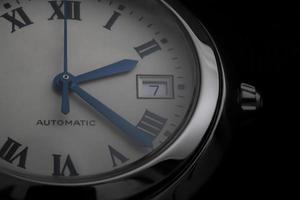 Nahaufnahme einer automatischen Schweizer Uhr mit blauen Zeigern, Datumsfenster und rundem Stahlgehäuse foto