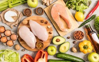 flache Zusammensetzung mit nützlichen Produkten, die ungesättigte Fettsäuren enthalten. Omega 3, Lachssteak, Avocado, Nüsse, Eier. grauer Hintergrund. foto