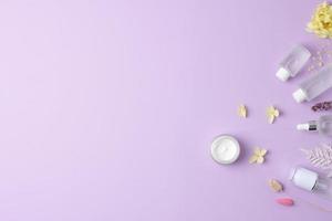 kosmetische hautpflegeprodukte mit blumen auf rosenhintergrund. flach liegend, kopierraum foto