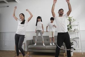 happy wellness asian thai family, eltern und kinder haben spaß beim gemeinsamen hula-hoop-spielen, fitnesstraining und gesunder übung im weißen wohnzimmer, häuslichem lebensstil und wochenendaktivitäten. foto