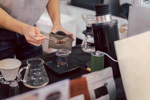 Barista misst geröstete Kaffeekörner auf einer Waage, bevor er Kaffee brüht. foto