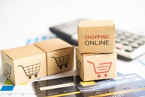 Online-Shopping-Box mit Kreditkarte und Taschenrechner im Diagramm. Geschäftskonzept für Finanzen, Handel, Import und Export. foto