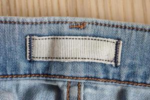 leeres Kleidungsetikett auf blauem Jeans-Denim-Hintergrund foto