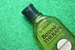 Ternopil, ukraine - 2. September 2022 Flasche Garnier Botanic Therapy Green Tea Shampoo auf grünem Glitzerhintergrund